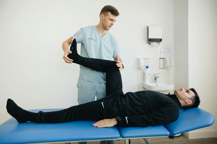 Un fisioterapeuta tractant a un pacient a la seva consulta.